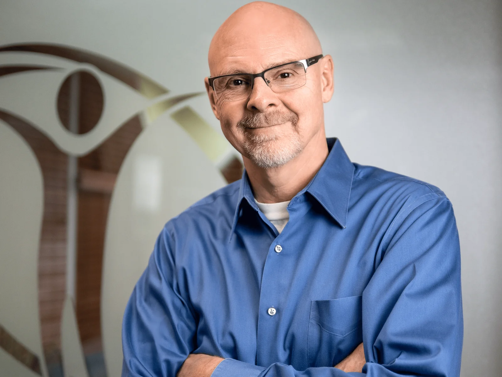 Dr. Charles Arndt standing in front of the Active Lifestyle Medical logo wall